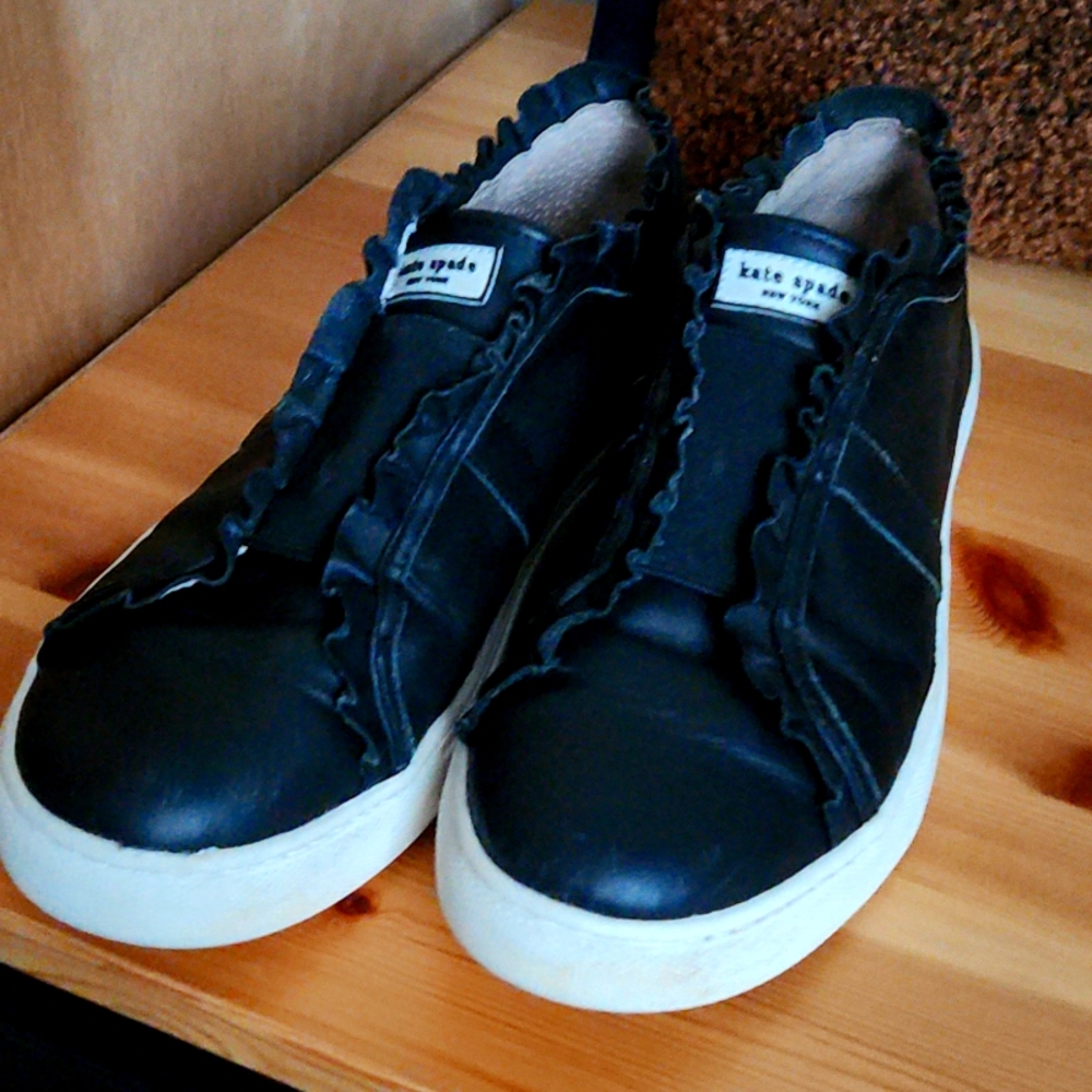 Black leather slip on sneakers by Kate Spade
